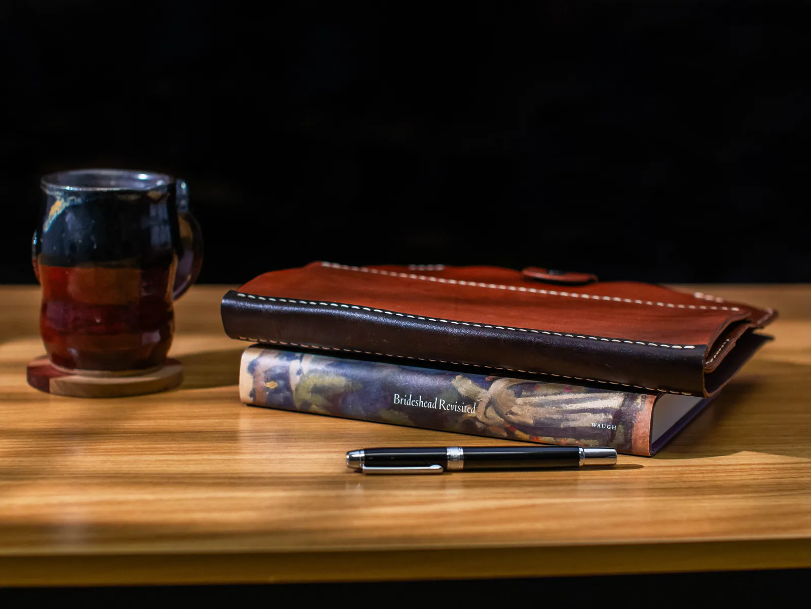 Closed Bookish folio stacked on a hardcover with a fountain pen