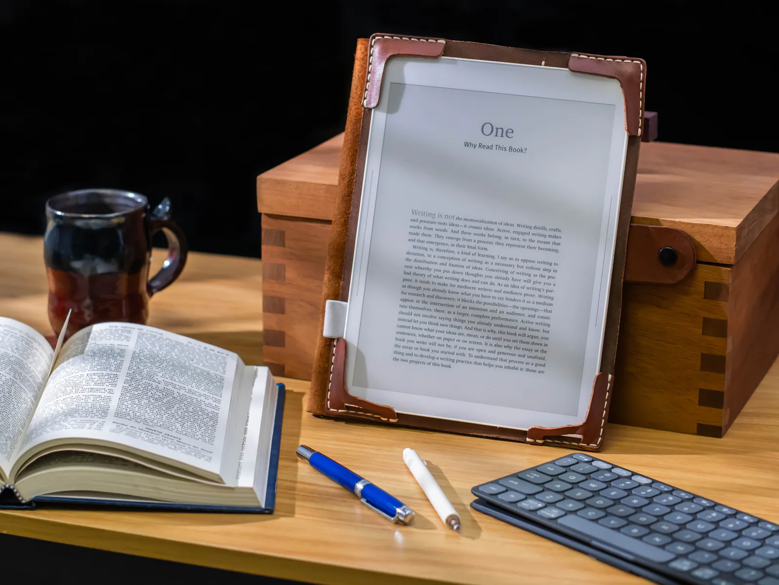 Bookish beside a wooden box and an open book