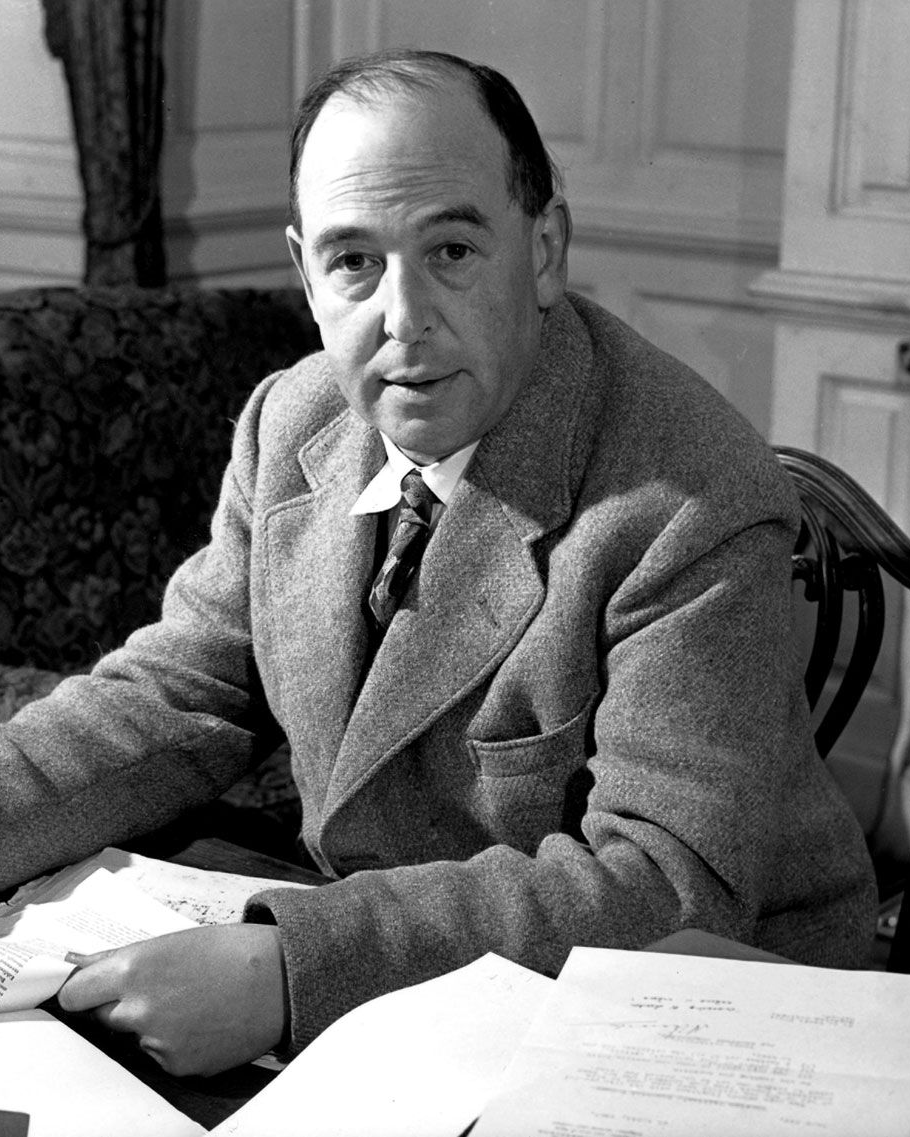 C. S. Lewis seated at his desk